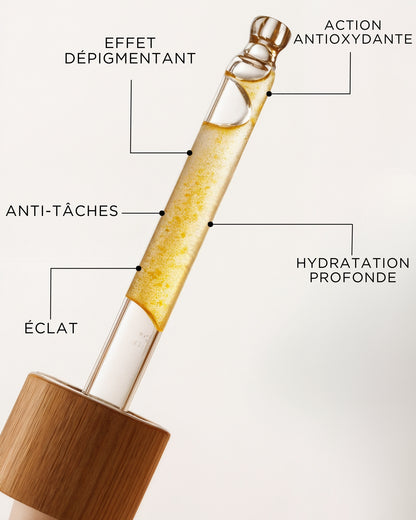 Skincare serum bottle with labeled benefits on a light gray background